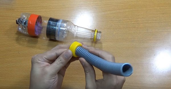 Gắn ống nhựa vào phần nắp chai nhựa để làm ống hút bụi